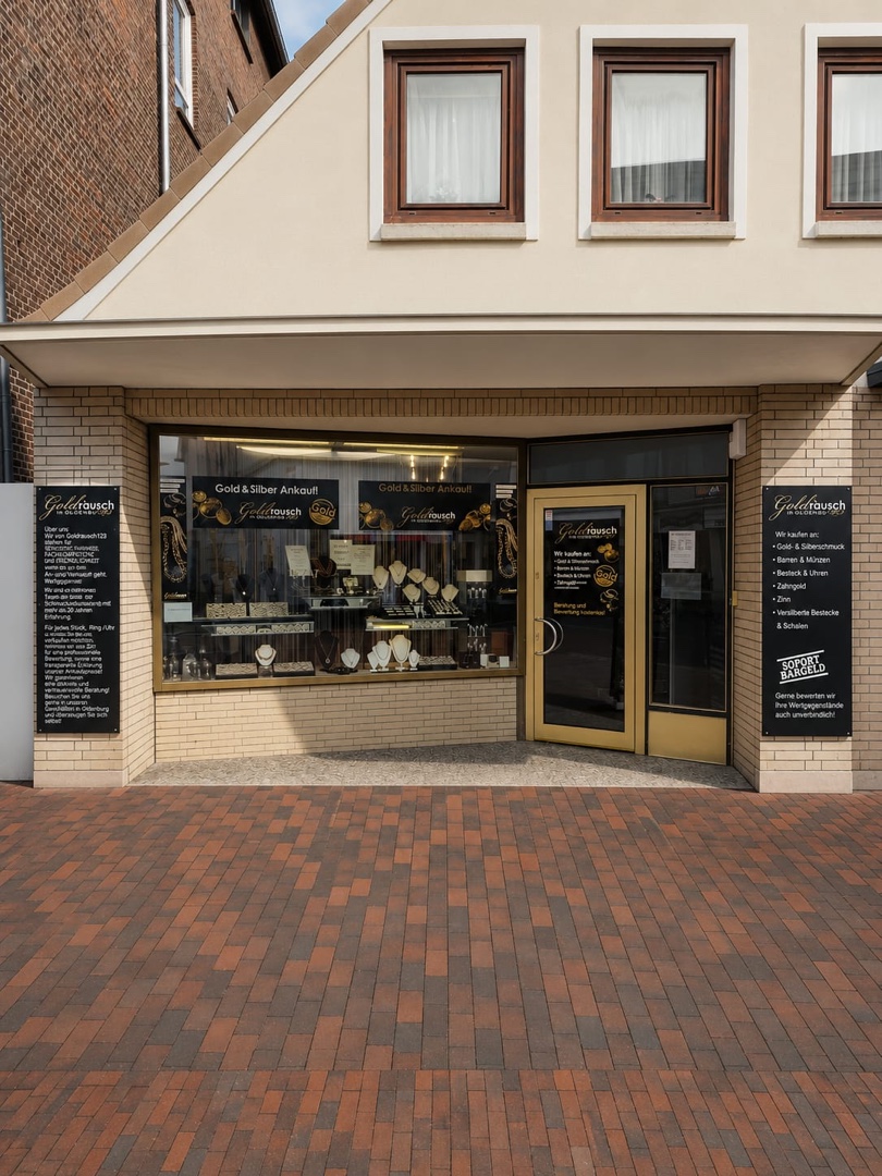 Ladenlokal von Goldrausch von außen: Schaufenster mit Schmuckauslage und Tafeln zum Gold- und Silberankauf neben dem Eingang